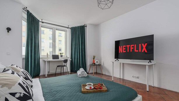 Une chambre d’hôtel avec un lit, un bureau, une télévision et un plateau avec de la nourriture.