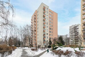A multi-story residential building with balconies, a paved pathway, and snow on the ground. - Stay in Warsaw Center (Warsaw)