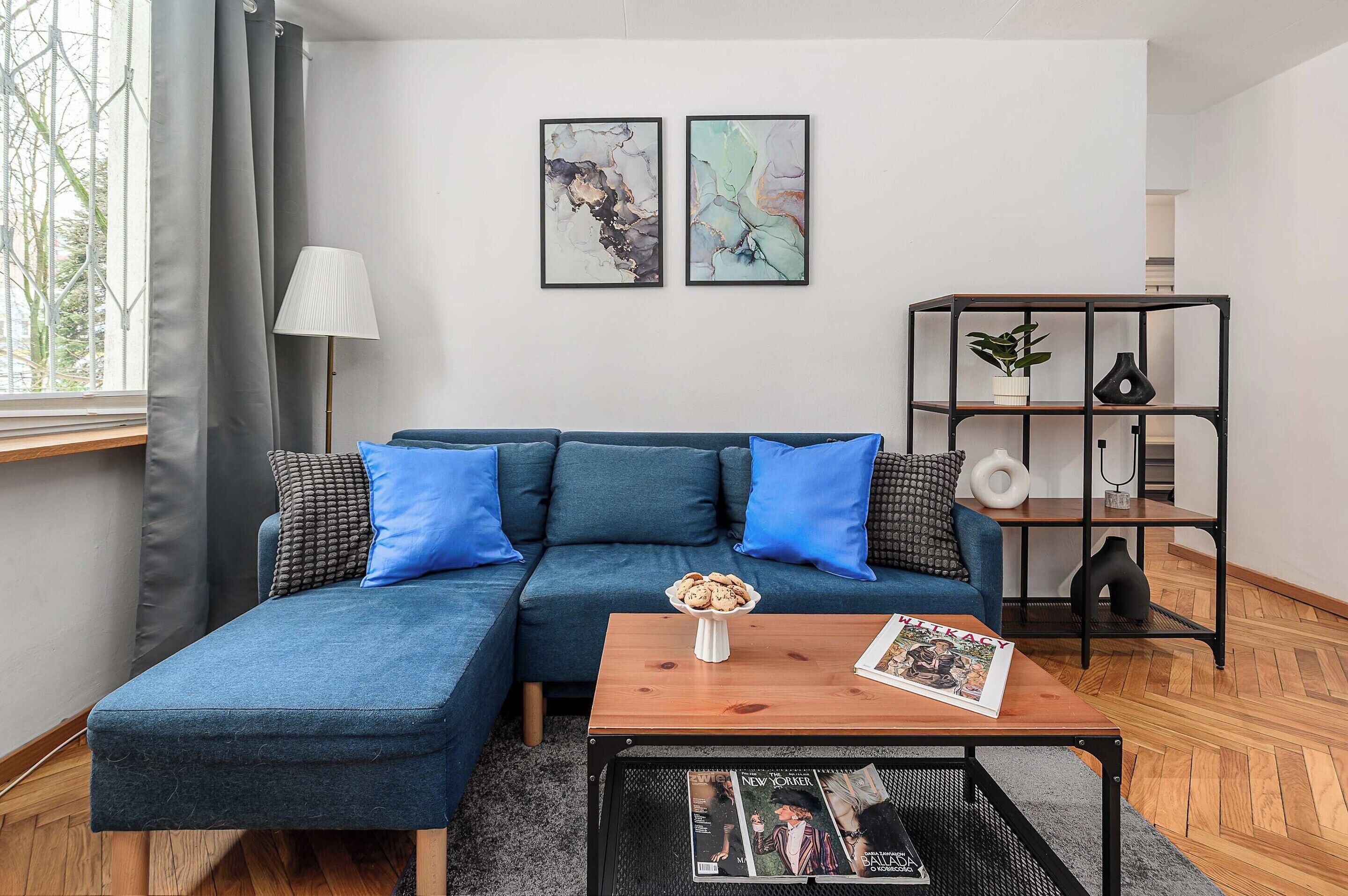 Een moderne woonkamer met een modulaire bank, een salontafel en een boekenkast.