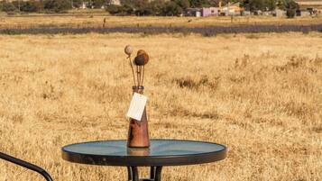 Una mesa redonda con base metálica, un objeto pequeño encima y una etiqueta adherida a la base.