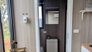 Una cocina moderna con horno integrado, un refrigerador pequeño y un microondas.