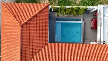 Ein Pool auf dem Dach mit einer Ziegeldach, ein Auto und ein Motorrad in der Nähe geparkt.