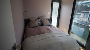 Un dormitorio con cama, ventana y puerta.