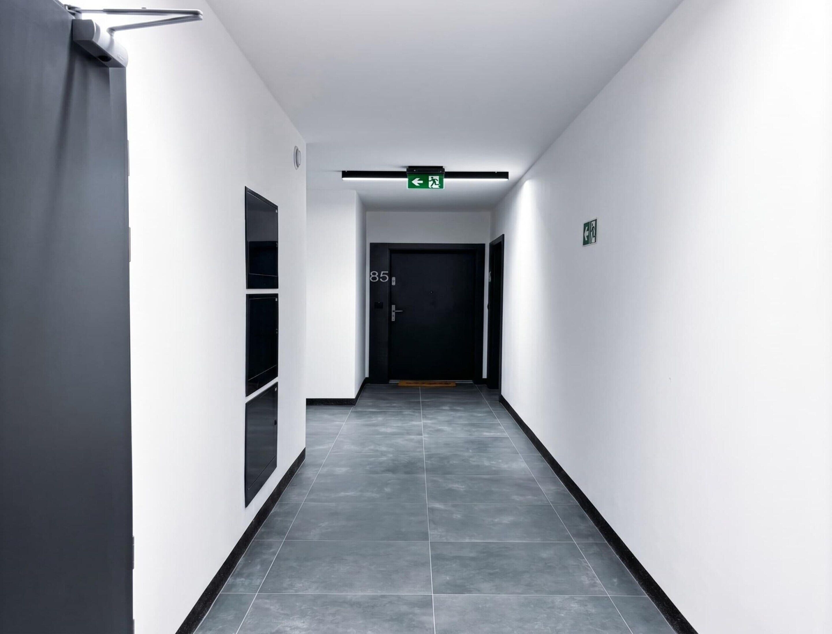 A corridor with a door marked '85' leading to a room.