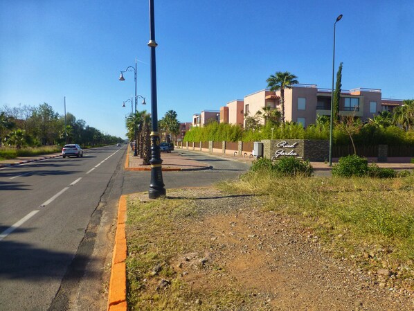 Eine Straße mit einem Verkehrsschild für 'Road Garden' und einem Gebäude mit Balkonen.