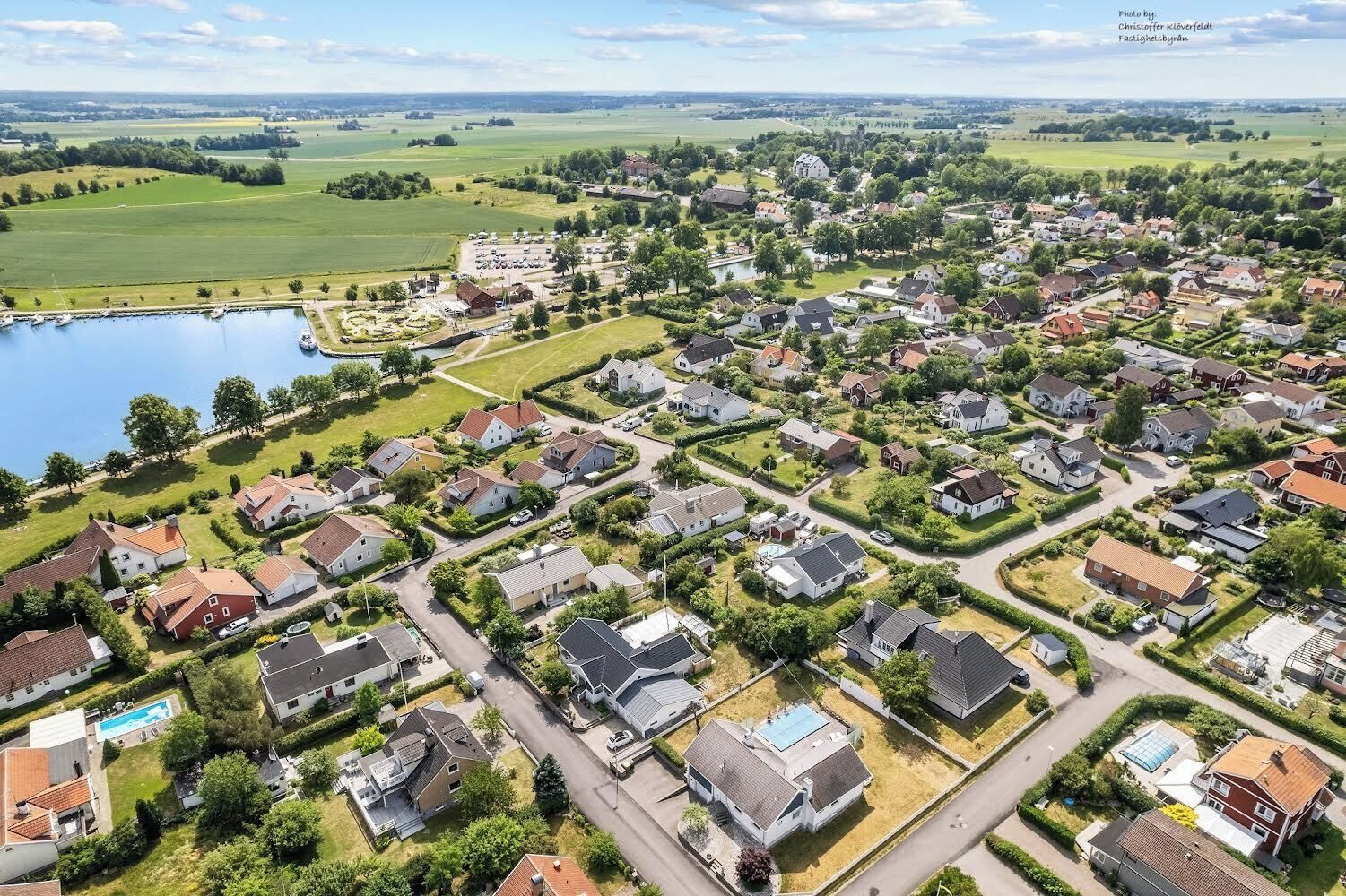 Vista aèria d'una zona residencial amb cases, carreteres i una massa d'aigua.