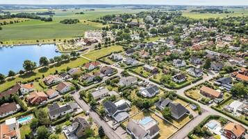 Vista aèria d'una zona residencial amb cases, carreteres i una massa d'aigua.