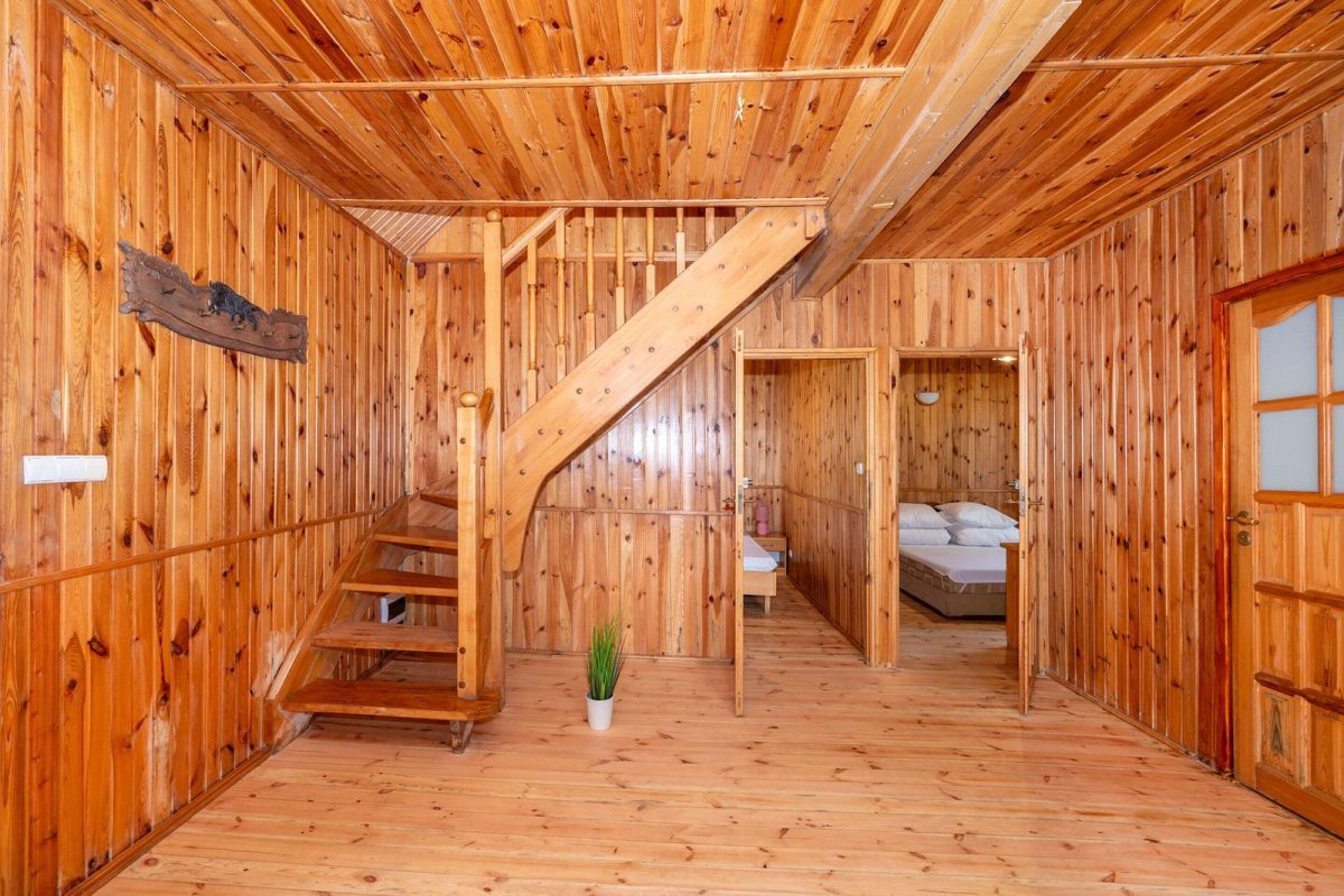A wooden interior with a staircase leading to a bedroom.