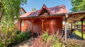 Ett trähus med en inglasad veranda och en trädgård framför.
