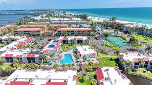 A resort with multiple buildings, a swimming pool, and a beach view. - Dans Florida Condos Beach Beckons at Runaway Bay (Bradenton Beach)