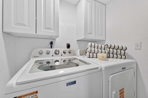 Eine Maytag Waschmaschine und Trockner Kombination mit Bedienelementen, ein Stapel Handtücher und eine Seife.