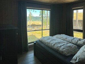 Ein Schlafzimmer mit einem Bett, einem Fenster und Holzboden.