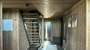 Un intérieur en bois avec un escalier menant à une porte.