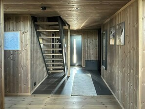 A wooden interior with a staircase leading to a door. - Sunny retreat on Nesfjellet near alpine skiing (Buskerud)