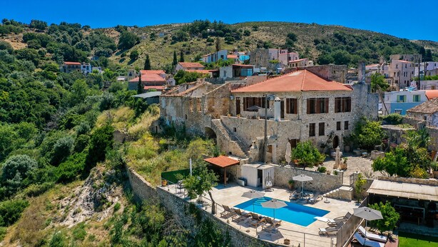 A stone building with a red-tiled roof, a swimming pool, and a hillside backdrop. - Villa Candice With Private Pool (Rethymno)
