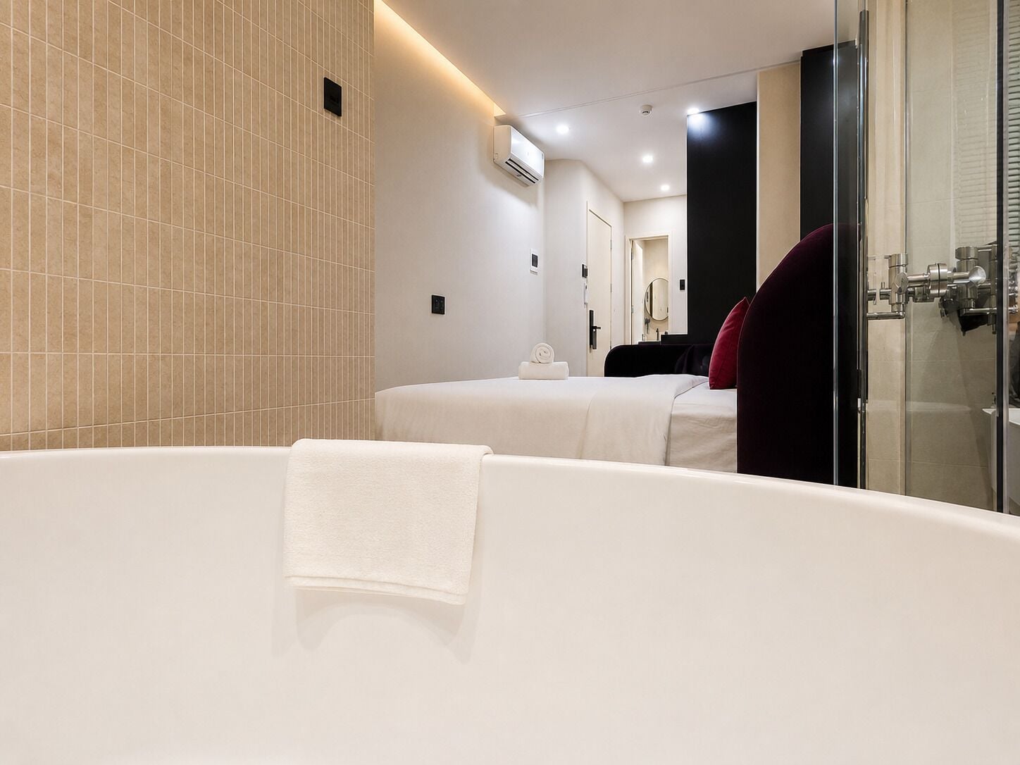 A modern bathroom with a large bathtub, a shower area, and a mirror.