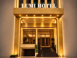 The entrance of the LUMI HOTEL with a modern design, featuring a prominent sign, a staircase, and a well-lit facade. - LUMI HOTEL BEN THANH (Ho Chi Minh City)