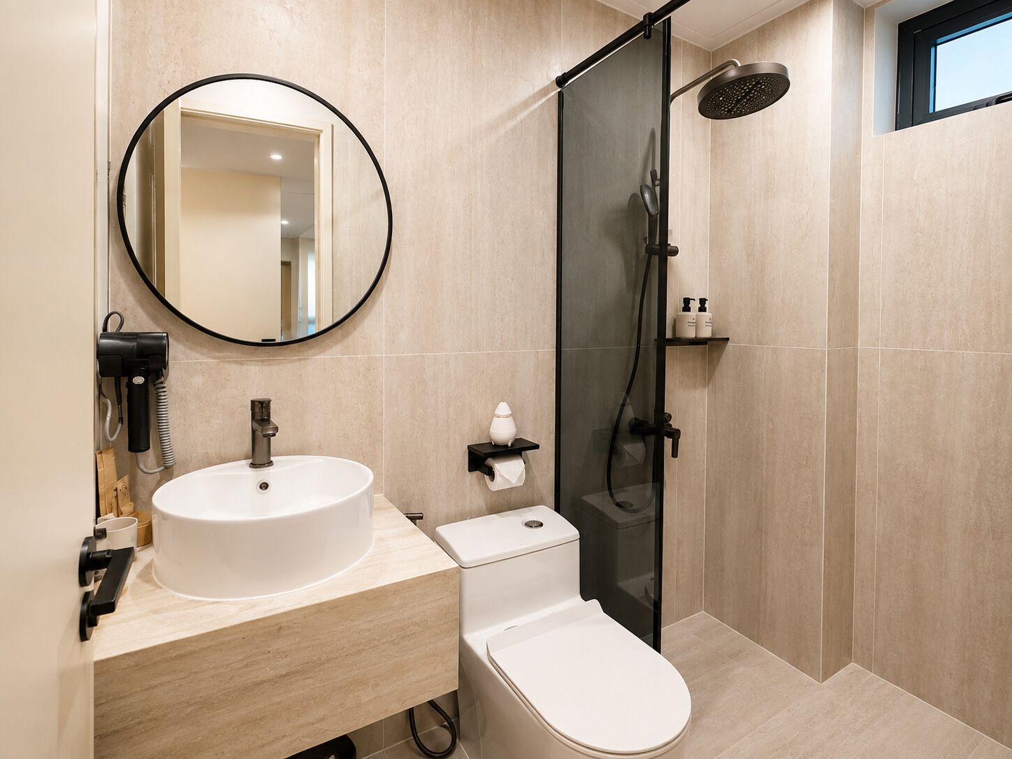 A modern bathroom with a round mirror, a sink, a toilet, and a glass-enclosed shower area.