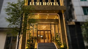 L’entrée d’un hôtel au design moderne, caractérisée par une bande lumineuse verticale et une façade en verre.