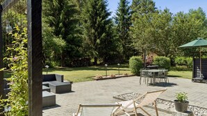 An outdoor patio with a table and chairs, surrounded by a stone wall and greenery. - 4 Star Holiday Home in Ronde (Ronde)