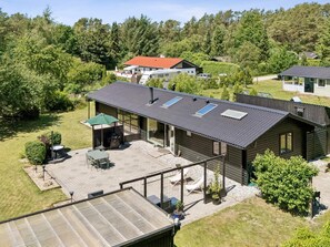A modern house with a large patio, a covered outdoor seating area, and a sloped roof with skylights. - 4 Star Holiday Home in Ronde (Ronde)