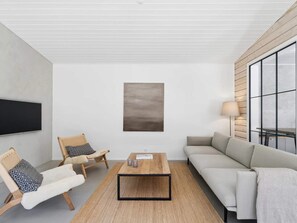 A modern living room with a flat-screen TV, a coffee table, a sofa, and a chair. - 4 Star Holiday Home in Ronde (Ronde)
