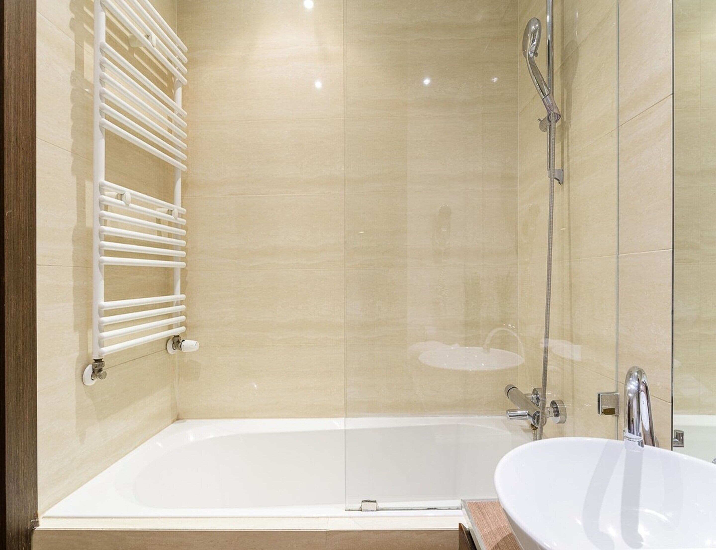 A modern bathroom with a bathtub, a shower, and a sink.