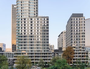 A modern high-rise building with multiple floors, large windows, and a curved facade. - Flat on Grzybowska Street (Warsaw)