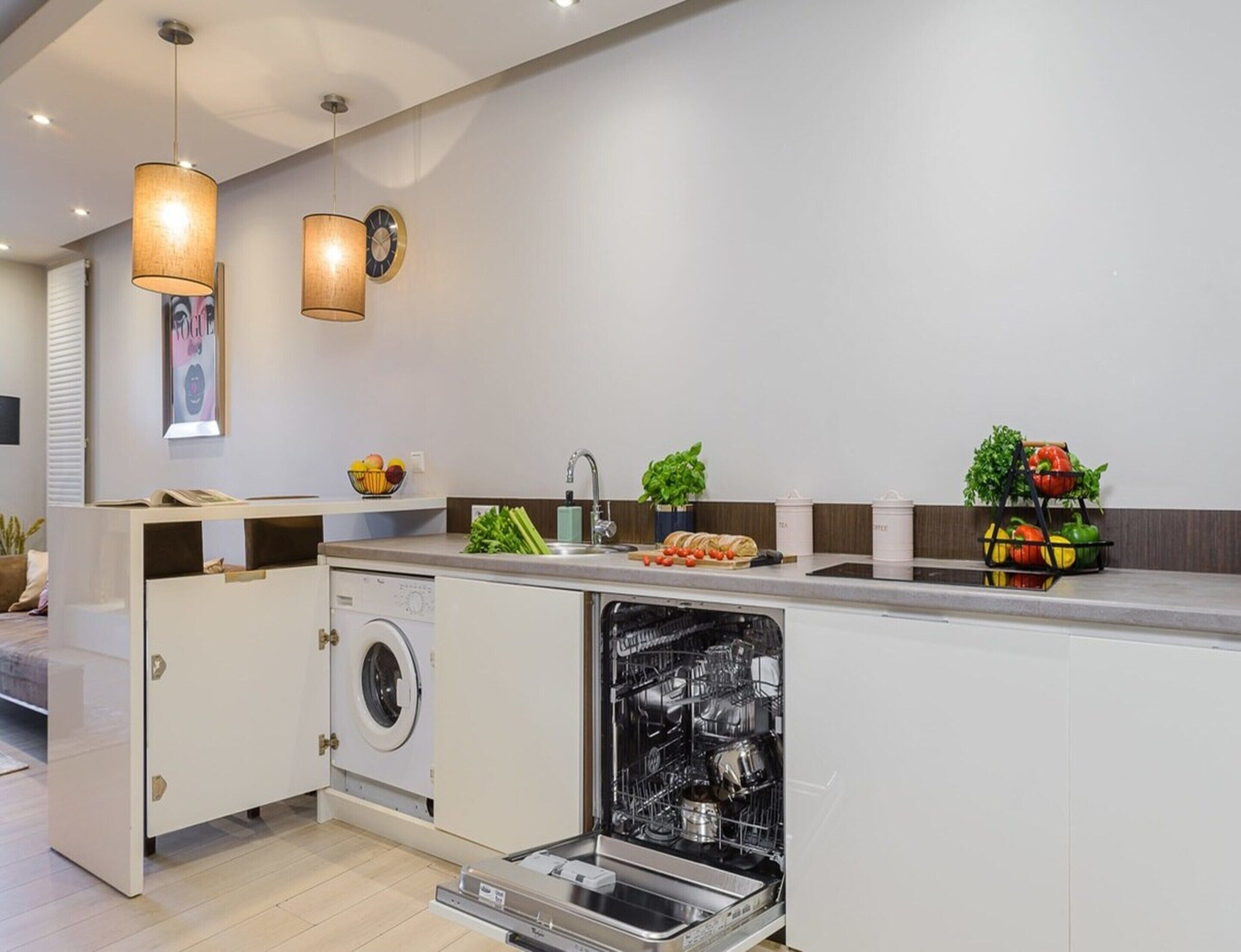 A modern kitchen with built-in appliances, a sink, and a dishwasher.