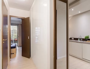 A modern hotel room with a wooden floor, a view of the outside balcony, and a kitchenette with a sink and countertop. - Flat on Grzybowska Street (Warsaw)