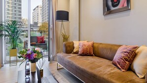 Ein modernes Wohnzimmer mit einer Couch, einem Couchtisch und einer Stehlampe.