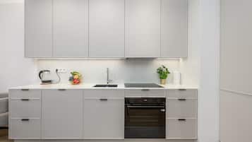 Una cocina moderna con armarios blancos, lavavajillas integrado y horno Samsung.
