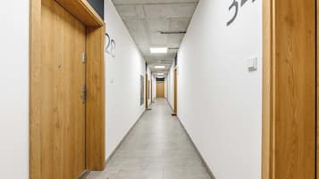 Un pasillo con puertas de madera, con los números 28 y 34, que dan a varias habitaciones.