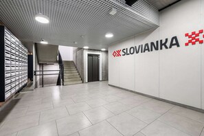 A modern interior with a staircase, a wall-mounted elevator, and a sign reading 'SLOVIANKA'. - Coastal Retreat for 4 With Terrace (Łódź)