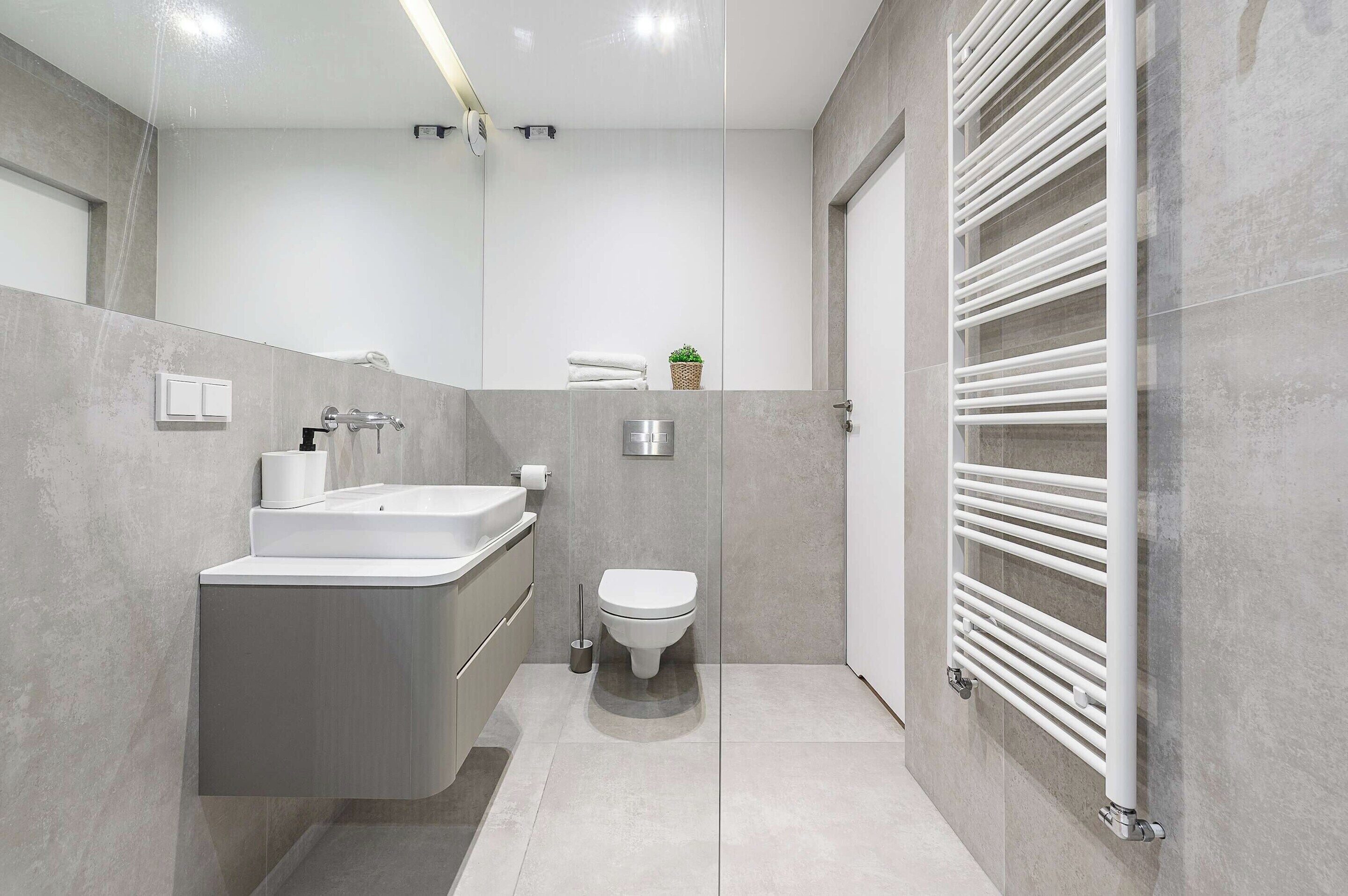 Une salle de bain moderne avec un lavabo intégré, des toilettes et un porte-serviettes.