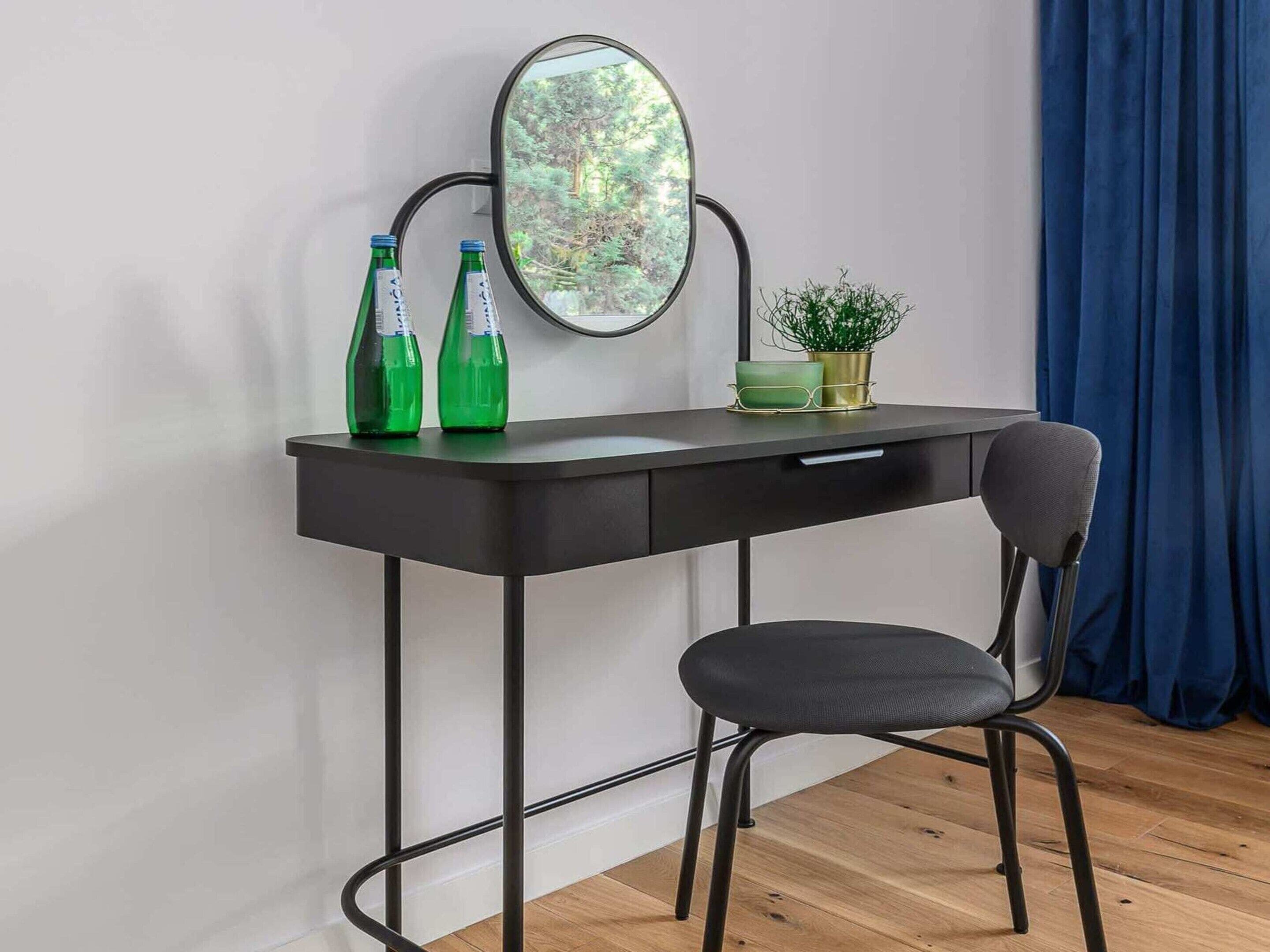 Un bureau moderne avec une chaise, une plante en pot et deux bouteilles vertes posées sur le bureau.