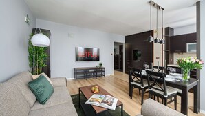 Een moderne woonkamer met een bank, salontafel en een eethoek met stoelen en een tafel.