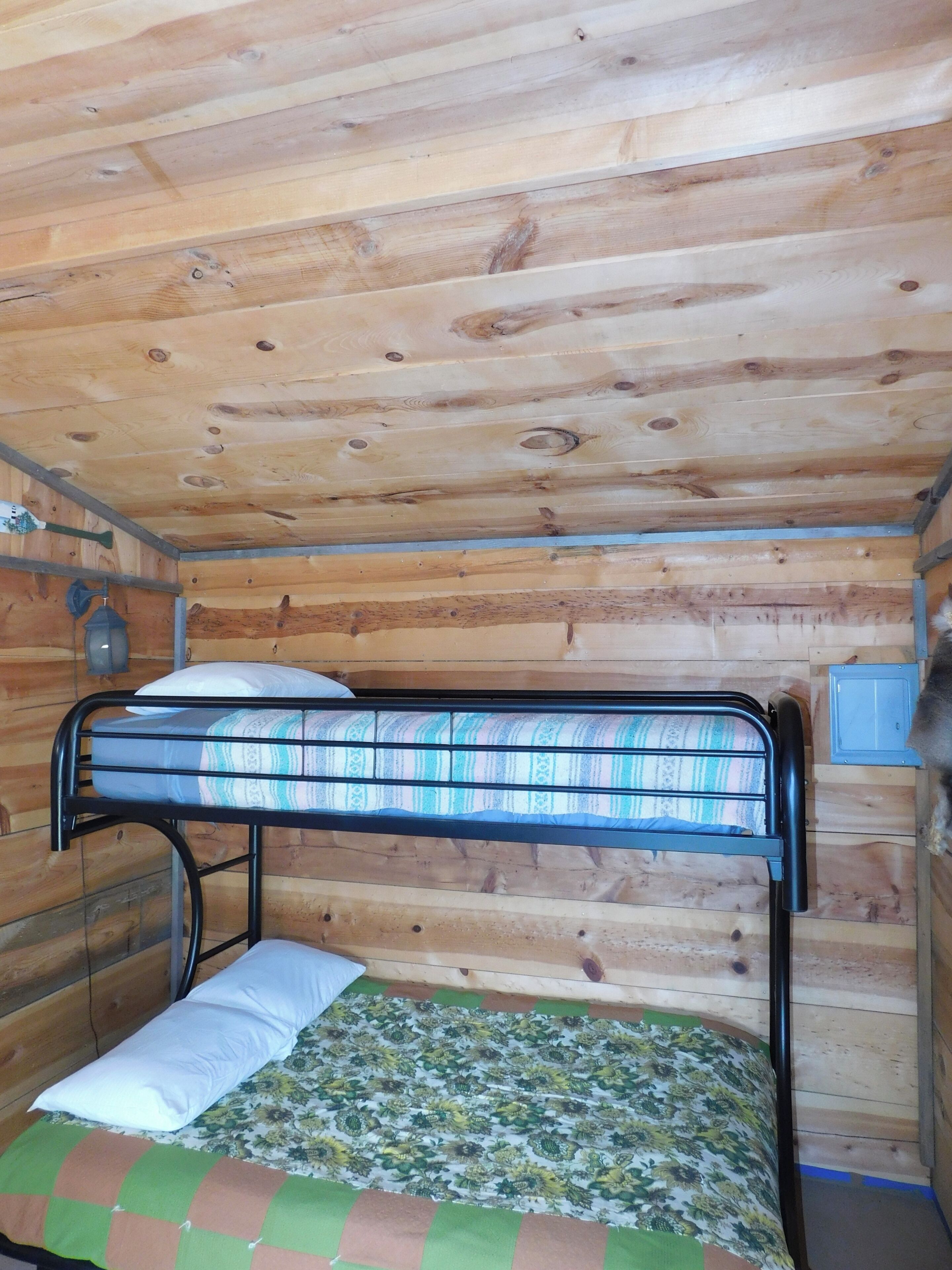 A bunk bed with a patterned mattress and a floral bedspread.