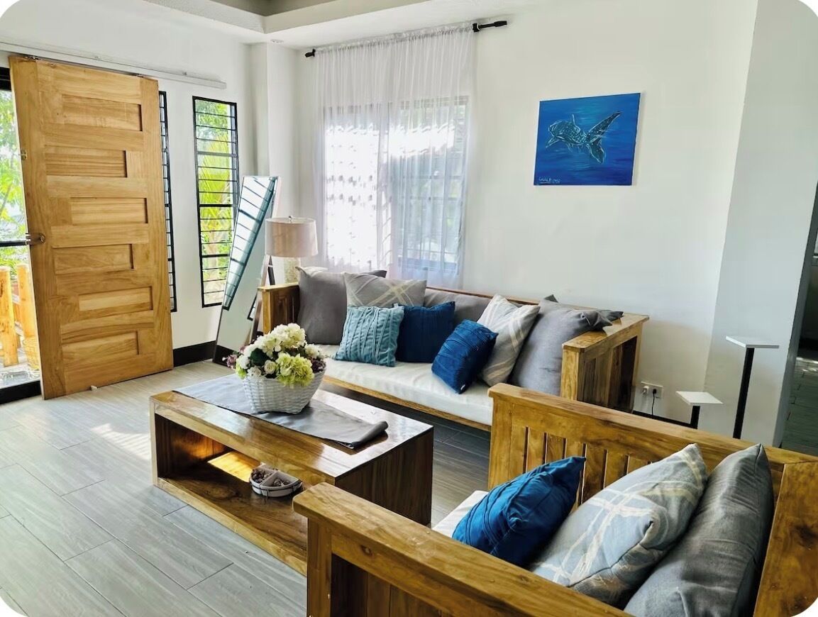 Una sala de estar con sofá, mesa de centro y una puerta de madera.
