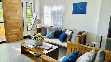 Una sala de estar con sofá, mesa de centro y una puerta de madera.