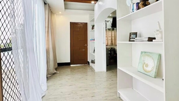 A hallway with a wooden ceiling, white walls, and a white door at the end. - Ocean View Villa w/ Infinity edge Pool, AC Comfort & Bohol Island Bliss (Lila)