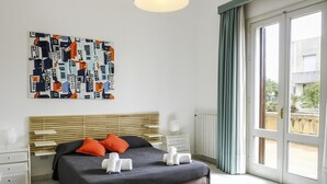 A bedroom with a bed, bedside tables, a radiator, and a window with curtains. - Villa in Sicily With Pool Near Erice & Trapani (Marsala)