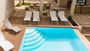 A poolside area with lounge chairs and a swimming pool. - Villa in Sicily With Pool Near Erice & Trapani (Marsala)