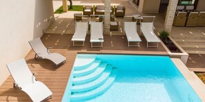 A poolside area with lounge chairs and a swimming pool. - Villa in Sicily With Pool Near Erice & Trapani (Marsala)