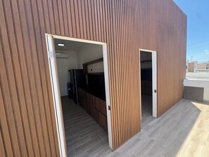 A modern building with a wooden exterior and a visible kitchen area with a refrigerator and cabinets. - Private apartment north of Hermosillo (Hermosillo)