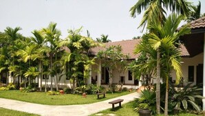 A courtyard with a building, palm trees, and a pathway.