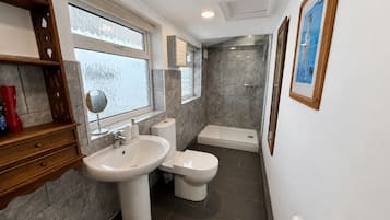 A bathroom with a sink, toilet, and shower.
