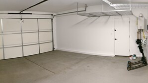 A garage with a white door, a ceiling fan, and a water heater mounted on the wall. - Star Light, Estrella Mountain Ranch (Goodyear)