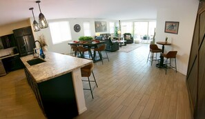 A spacious living area with a kitchen, dining area, and a large window providing natural light. - Star Light, Estrella Mountain Ranch (Goodyear)
