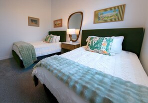 Ein Hotelzimmer mit zwei Betten, einem Nachttisch mit Lampe und Wandbildern.